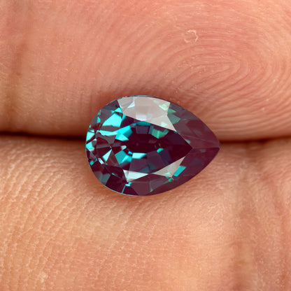 Pear sample resting on fingertips to provide real-world scale context.