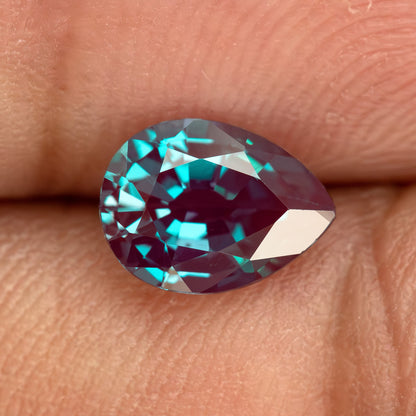 A second fingertip view of the pear sample, showing changing reflections at a different angle.