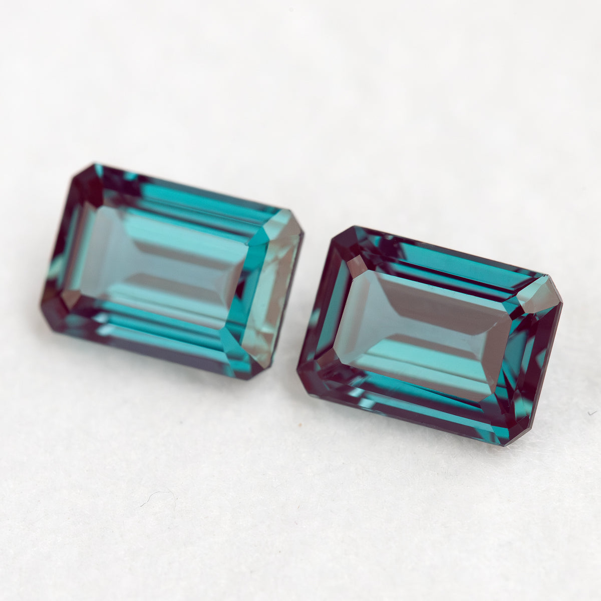 Two emerald-cut samples side by side on a pale surface, illustrating a pair layout.