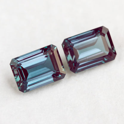 Two crown-facing emerald-cut lab-grown alexandrite samples in a diagonal arrangement, illustrating the pair purchase option.
