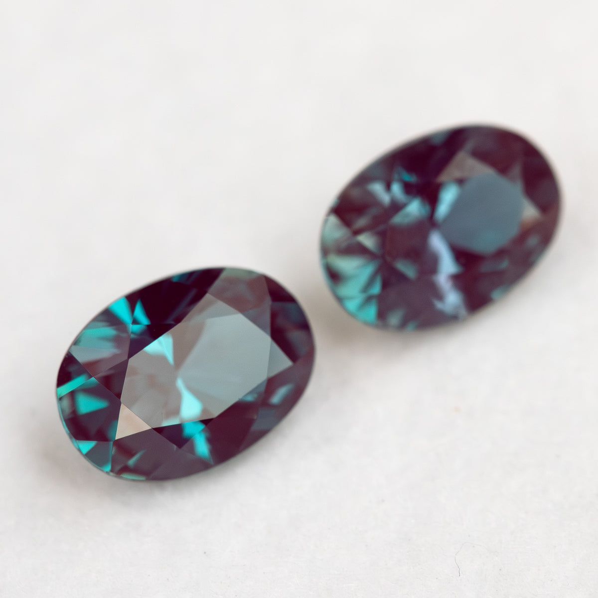 Two oval samples arranged diagonally, with the rear stone softly focused.