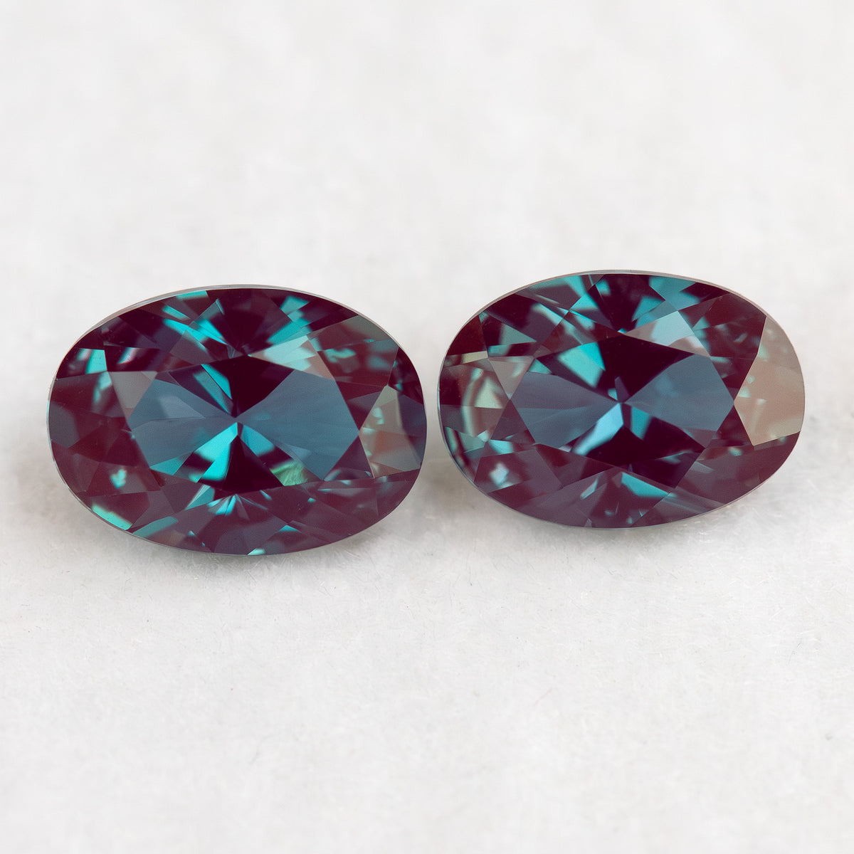 Two crown-facing oval lab-grown alexandrite samples side by side, illustrating the pair purchase option.
