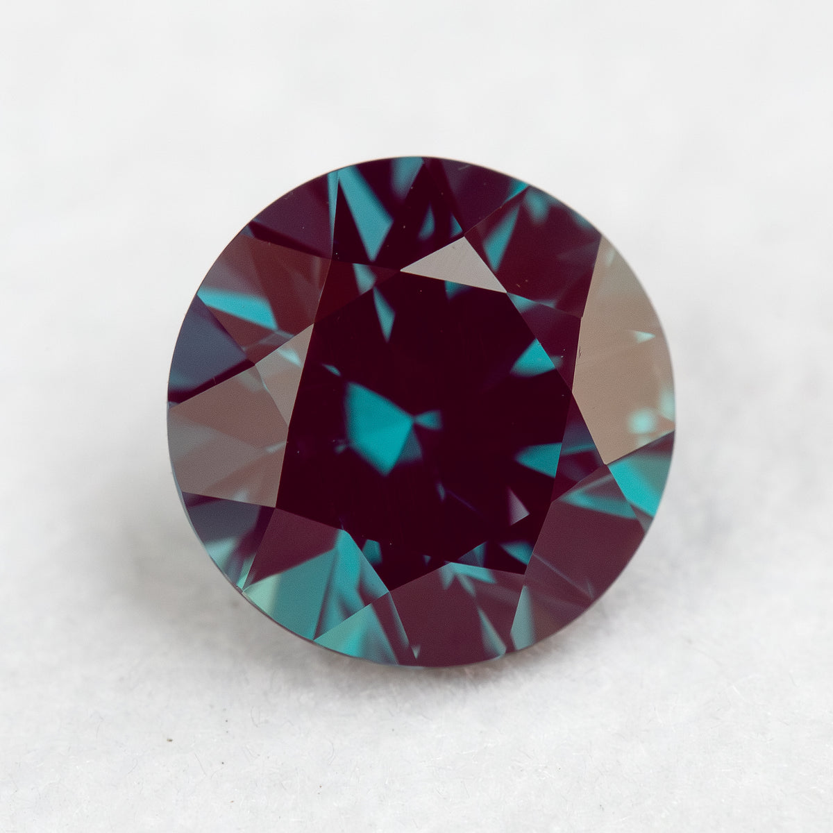 Round sample photographed at a different face-up angle with a dark reflected center.