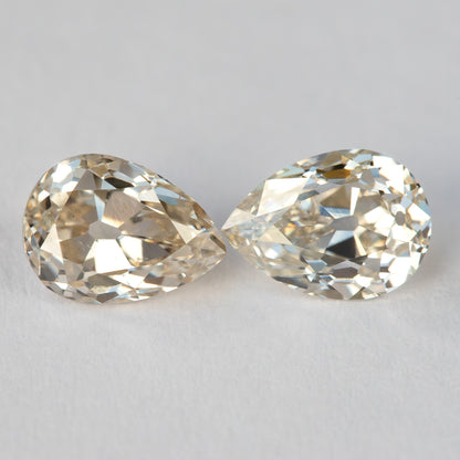 Vista frontal emparejada de los dos diamantes con sus puntas orientadas hacia adentro, mostrando diferencias en el contorno y el patrón de facetas.