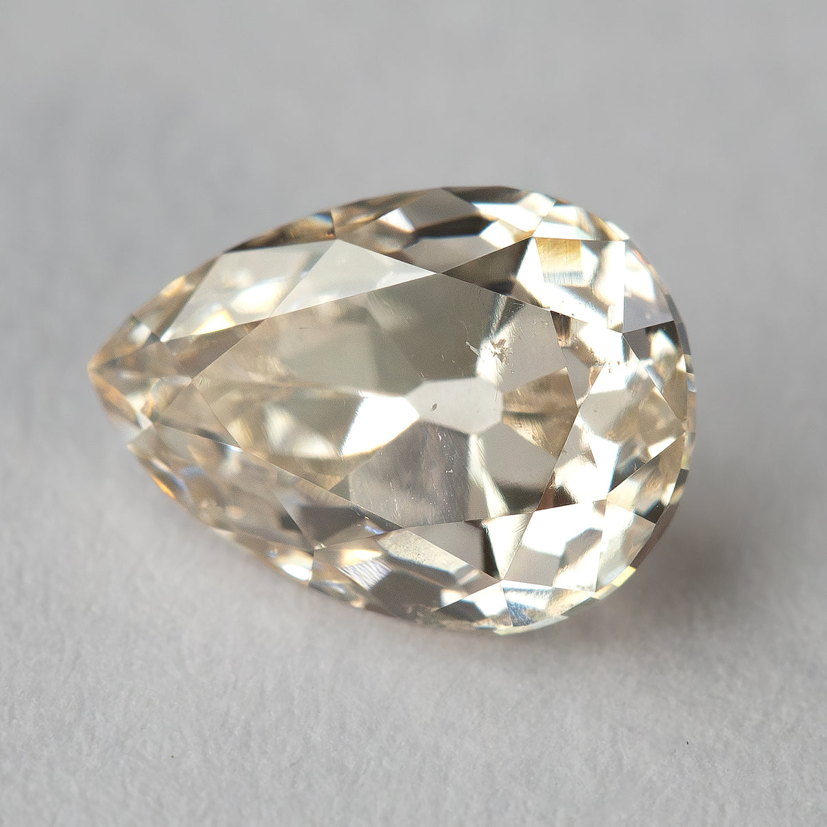 Close angled view of the old-mine pear-cut diamond, showing its broad facets and visible inclusions.