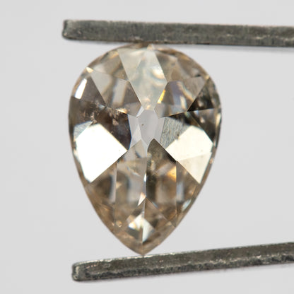 Pavilion view of the exact pear diamond held in tweezers, showing its back facet arrangement.
