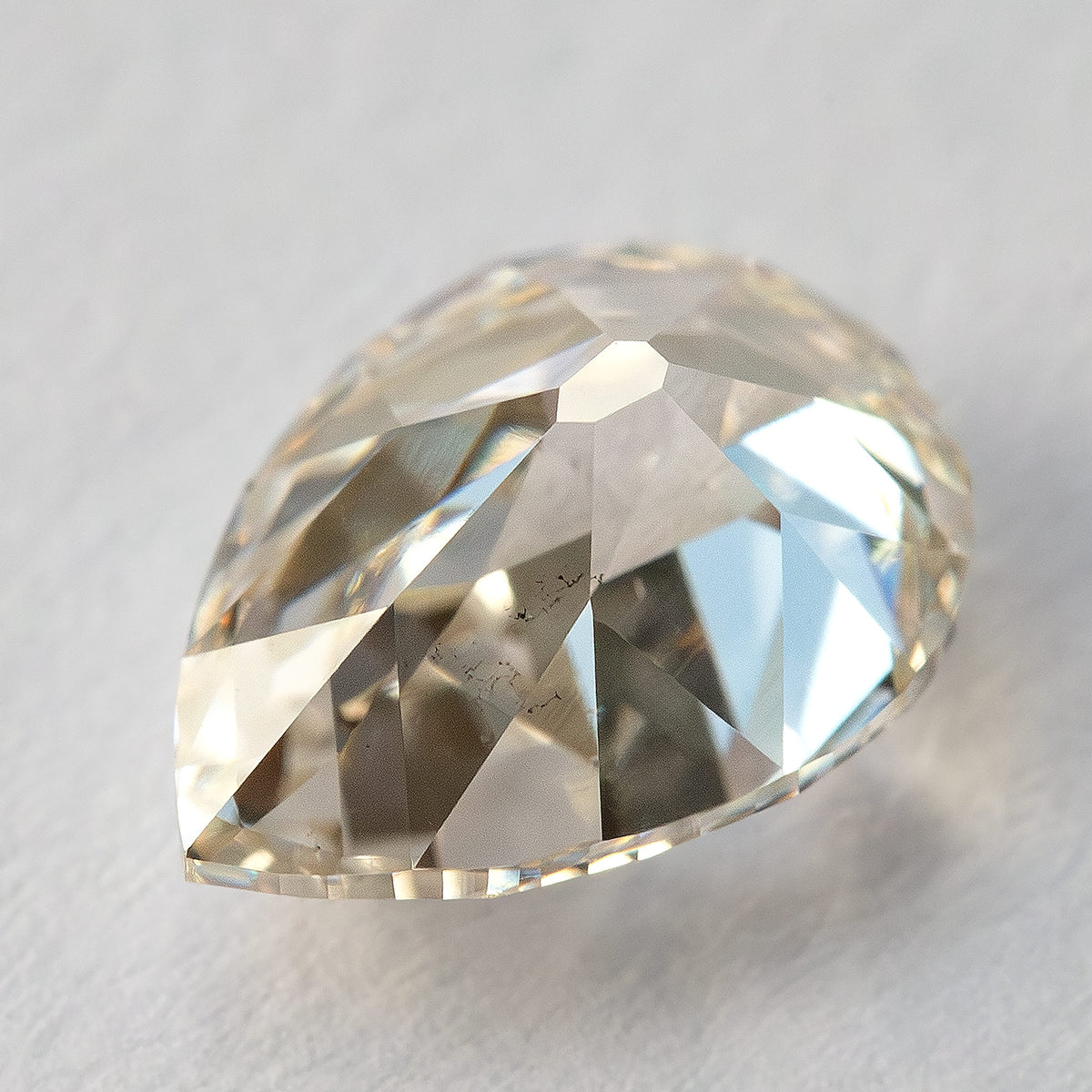 Tilted pavilion view of the lab-grown diamond, showing the lower facets and visible characteristics.
