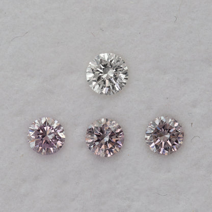 Face-up pink round diamond samples beneath one white comparison diamond on a pale background; purchase is per pink diamond.