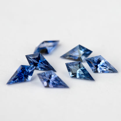 A closer angled view of the blue sapphire parcel, showing the varied length and width of the individual stones.