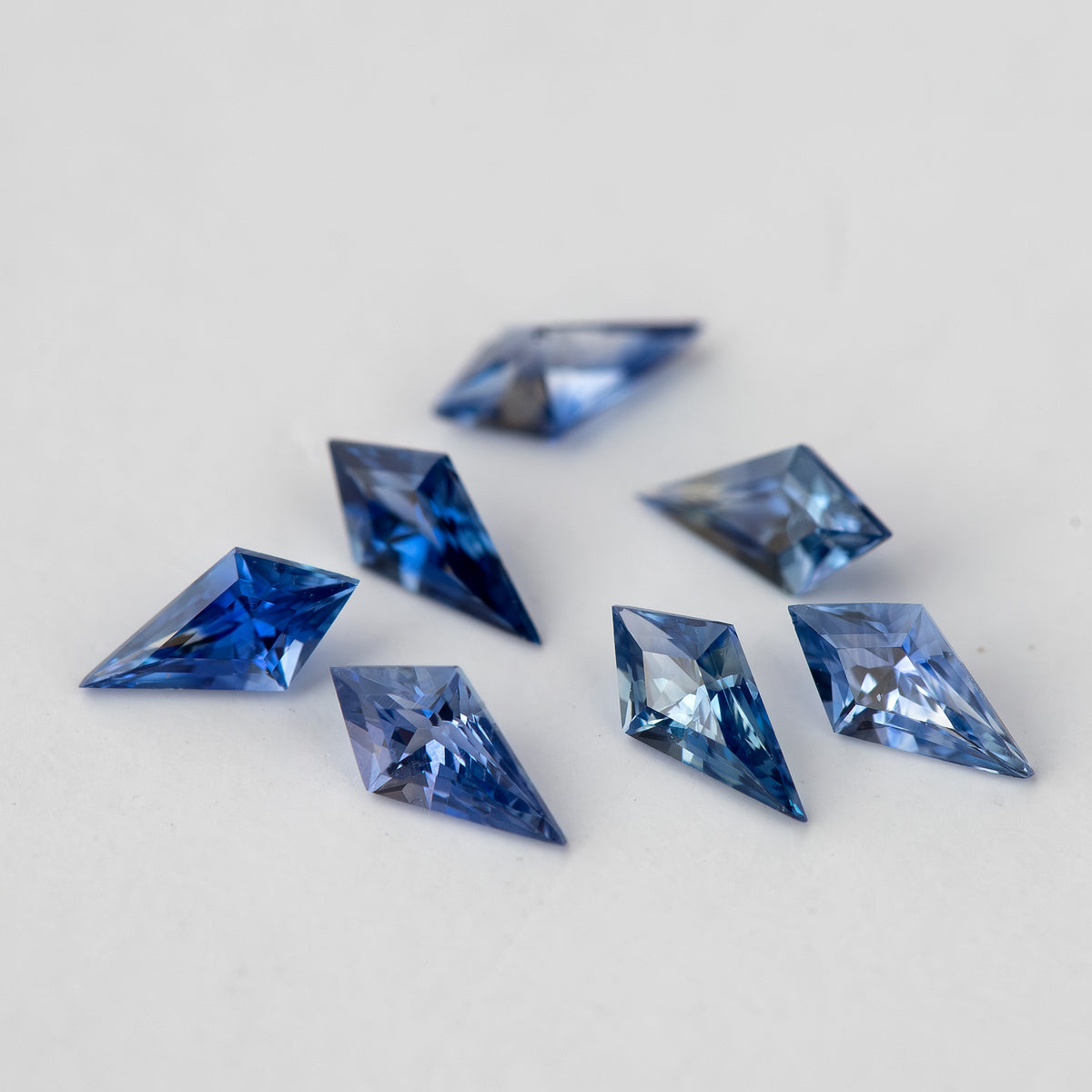 The seven kite-shaped sapphires viewed from another angle, showing alternating dark and pale blue facet reflections.