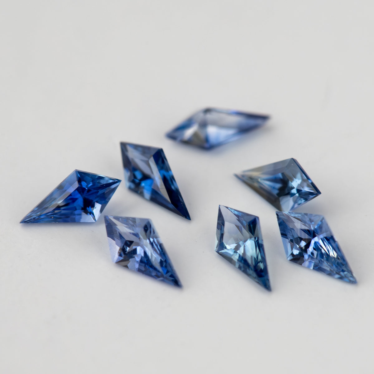 The blue sapphire parcel from a diagonal angle, showing the complete pointed outlines of the foreground stones.