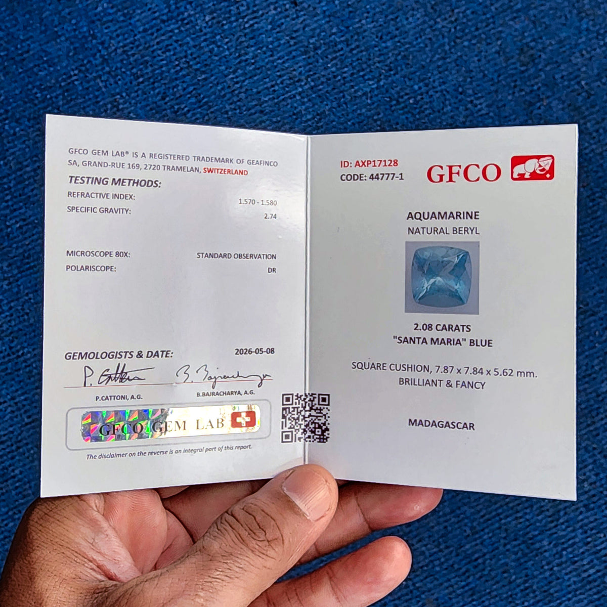 Informe del laboratorio de gemas GFCO AXP17128 para la acuamarina exacta de 2.08 ct, indicando el origen de Madagascar y las medidas.