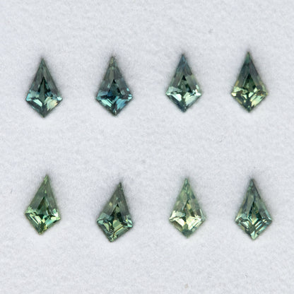 Angled overhead view of the original eight kite sapphires with bright facet reflections.