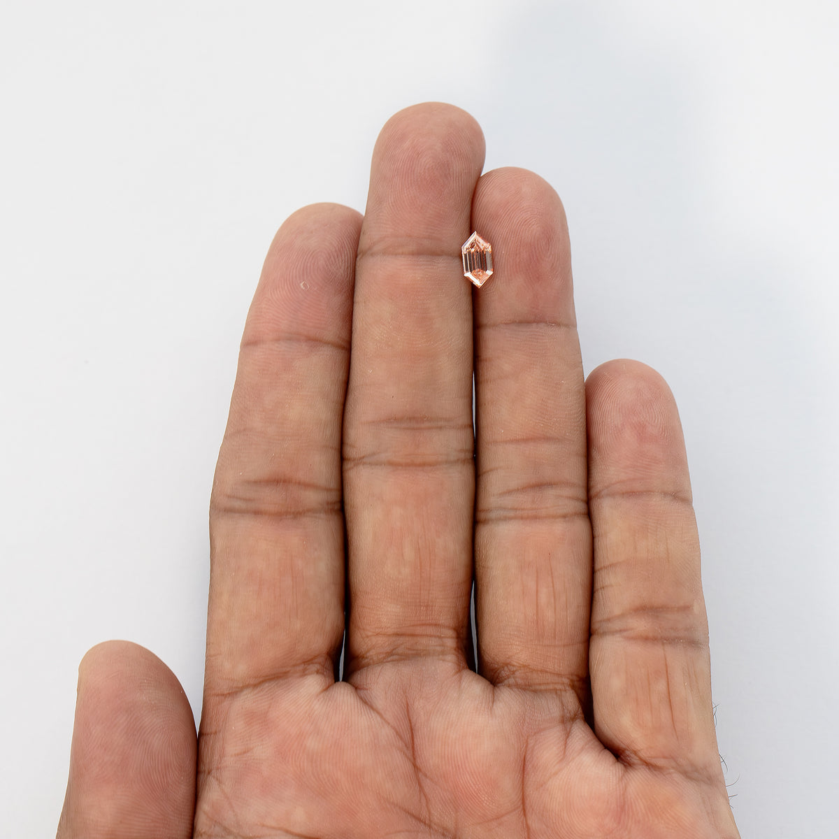 Full hand scale view showing the small physical size of the exact 0.77 ct loose diamond.