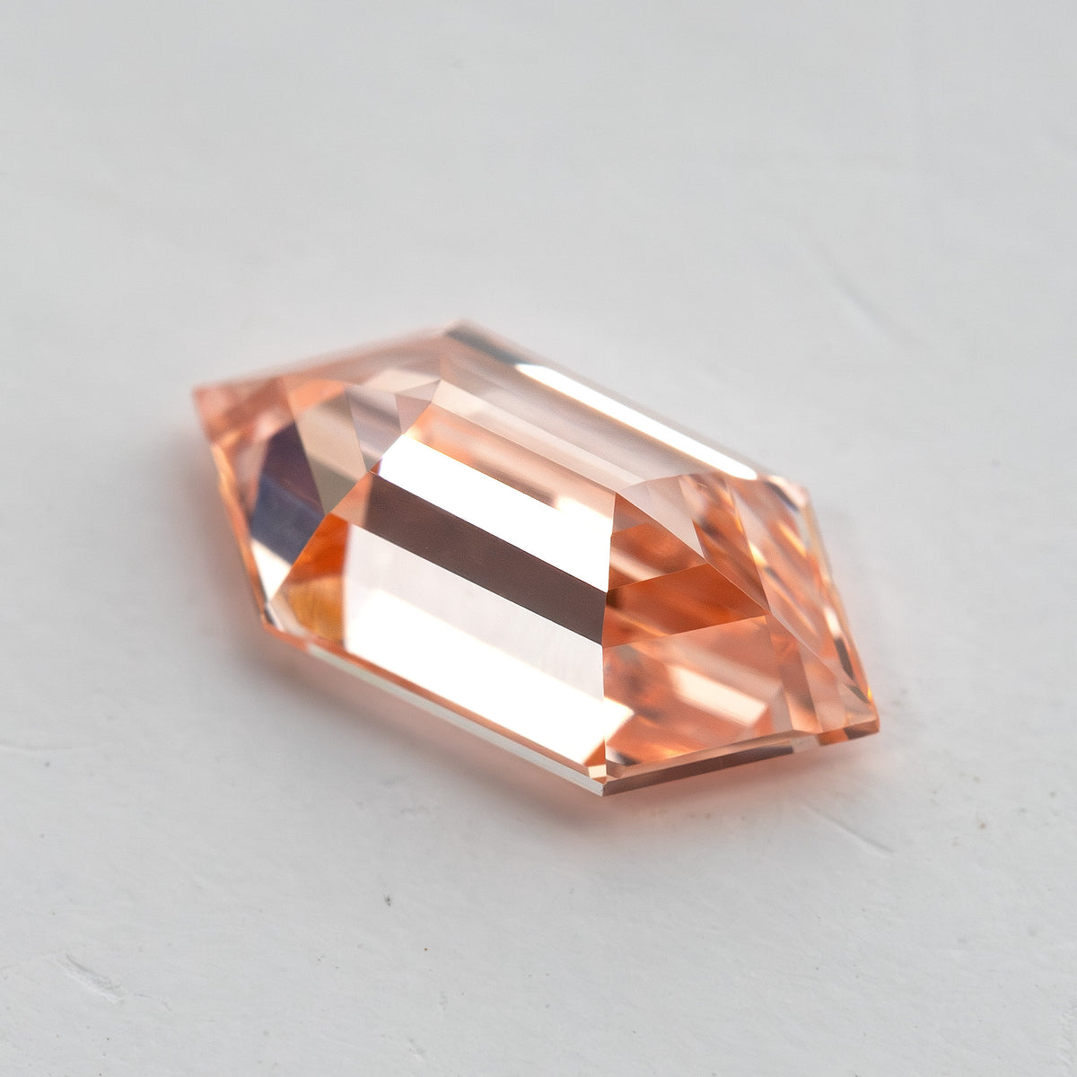 Reverse angled view of the diamond showing pavilion facet geometry and the elongated six-sided shape.