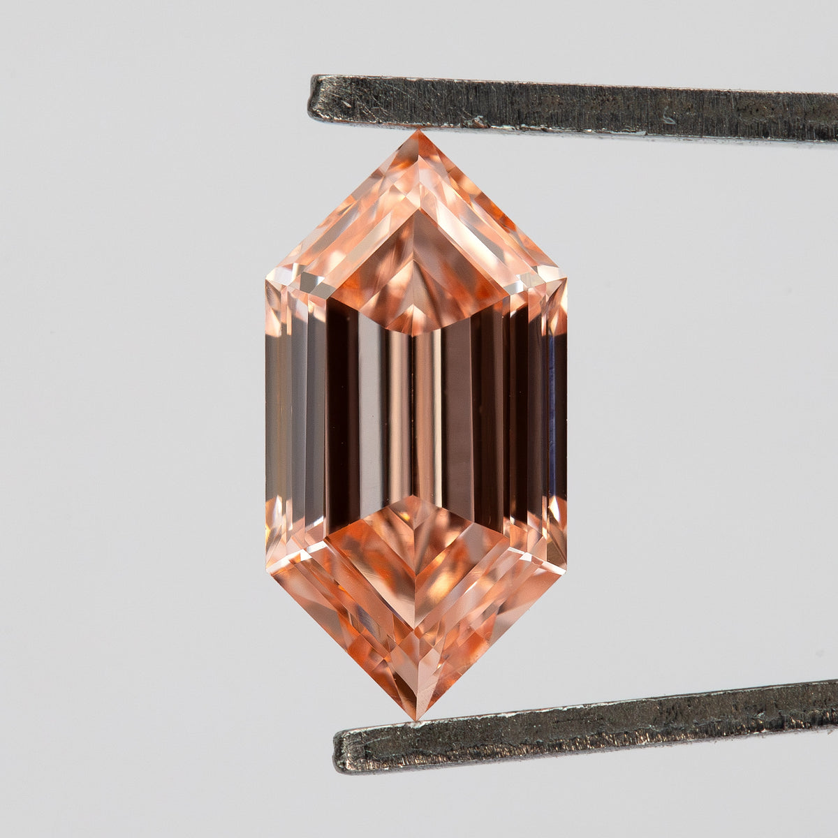 Vertical tweezer view showing the pointed ends, six-sided outline and strong geometric reflections.
