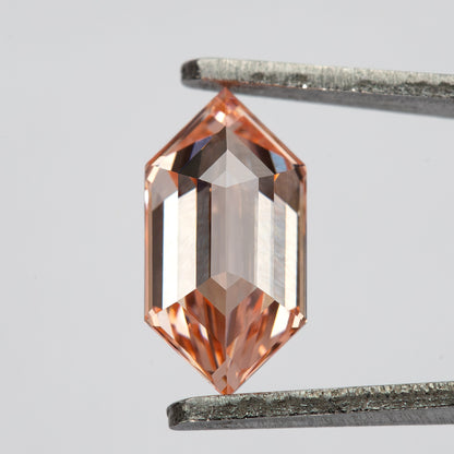 Angled tweezer view showing the step-cut pattern and deeper peach color near the pointed ends.