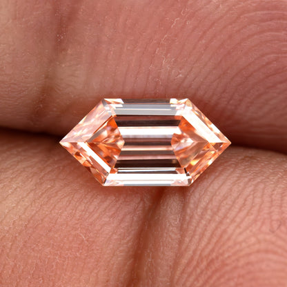 Horizontal finger view showing the exact diamond at hand scale with dark central step reflections.