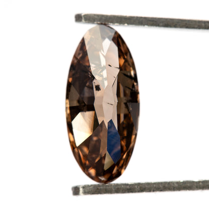 1.43 ct pinkish-brown lab-grown elongated oval diamond, close-up in tweezers, SKU BLD154