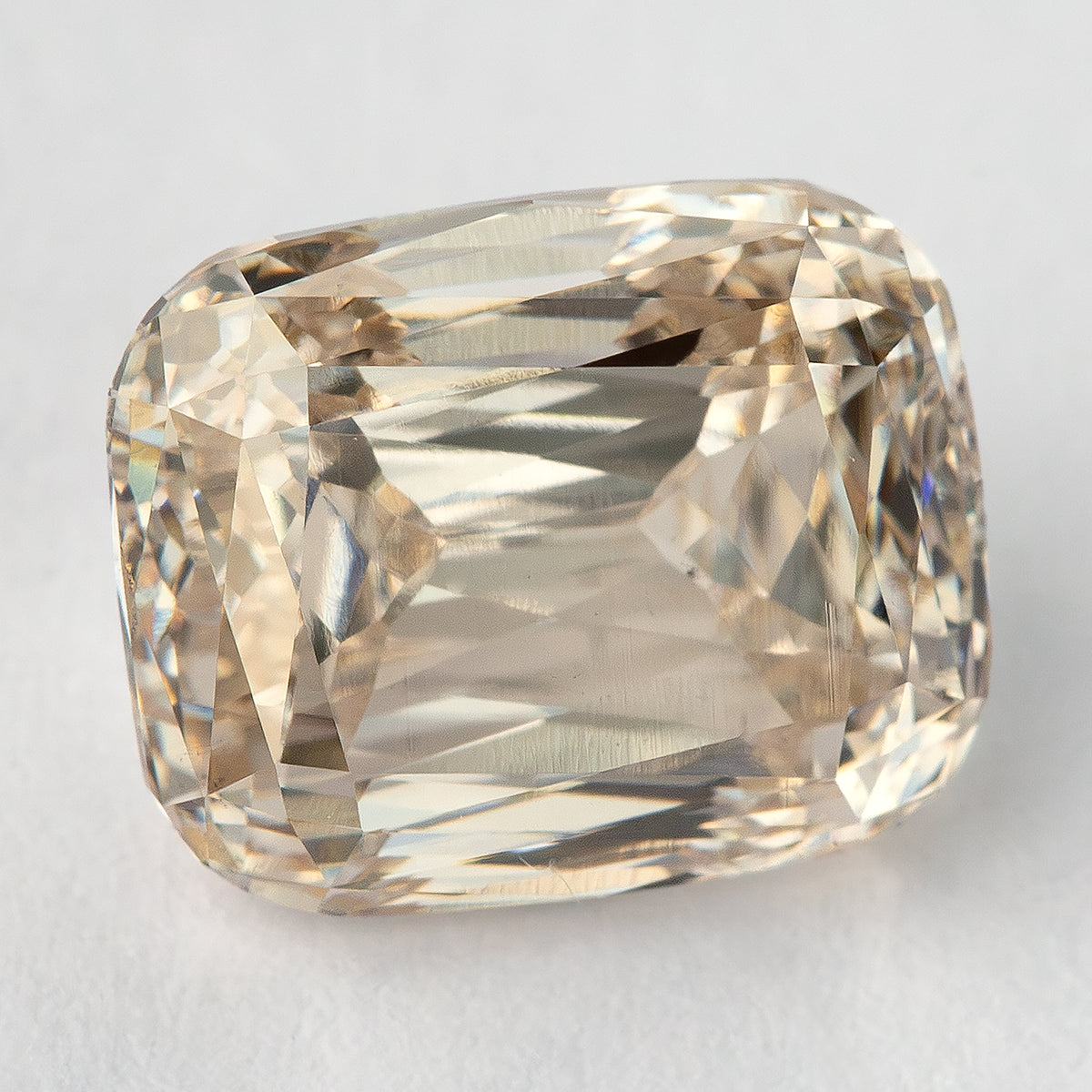 Alternate face-up view of the loose diamond on a light background, showing a different reflection pattern across its elongated cushion outline.