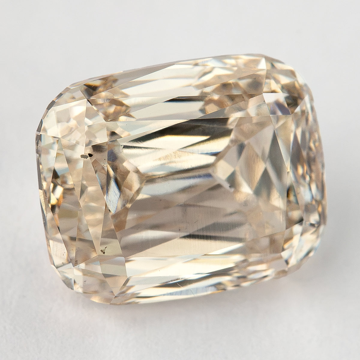 Close face-up view of the exact diamond on a light background, showing its visible characteristics and crisscross reflections.