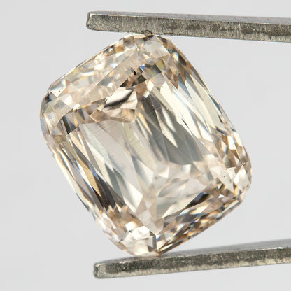 Steeper angled view of the diamond in tweezers, showing the rounded corners and modified-brilliant facet pattern.