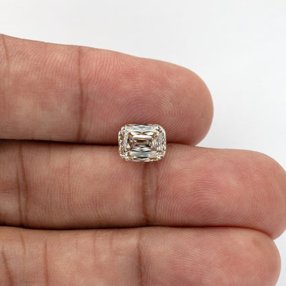 Wide hand-scale view of the loose diamond resting across fingers, showing its size in everyday context.