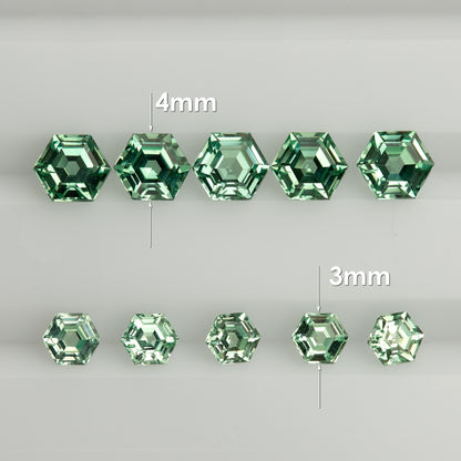 Two rows of mint green hexagonal lab-grown sapphires on a white tray, labelled 4mm above and 3mm below.