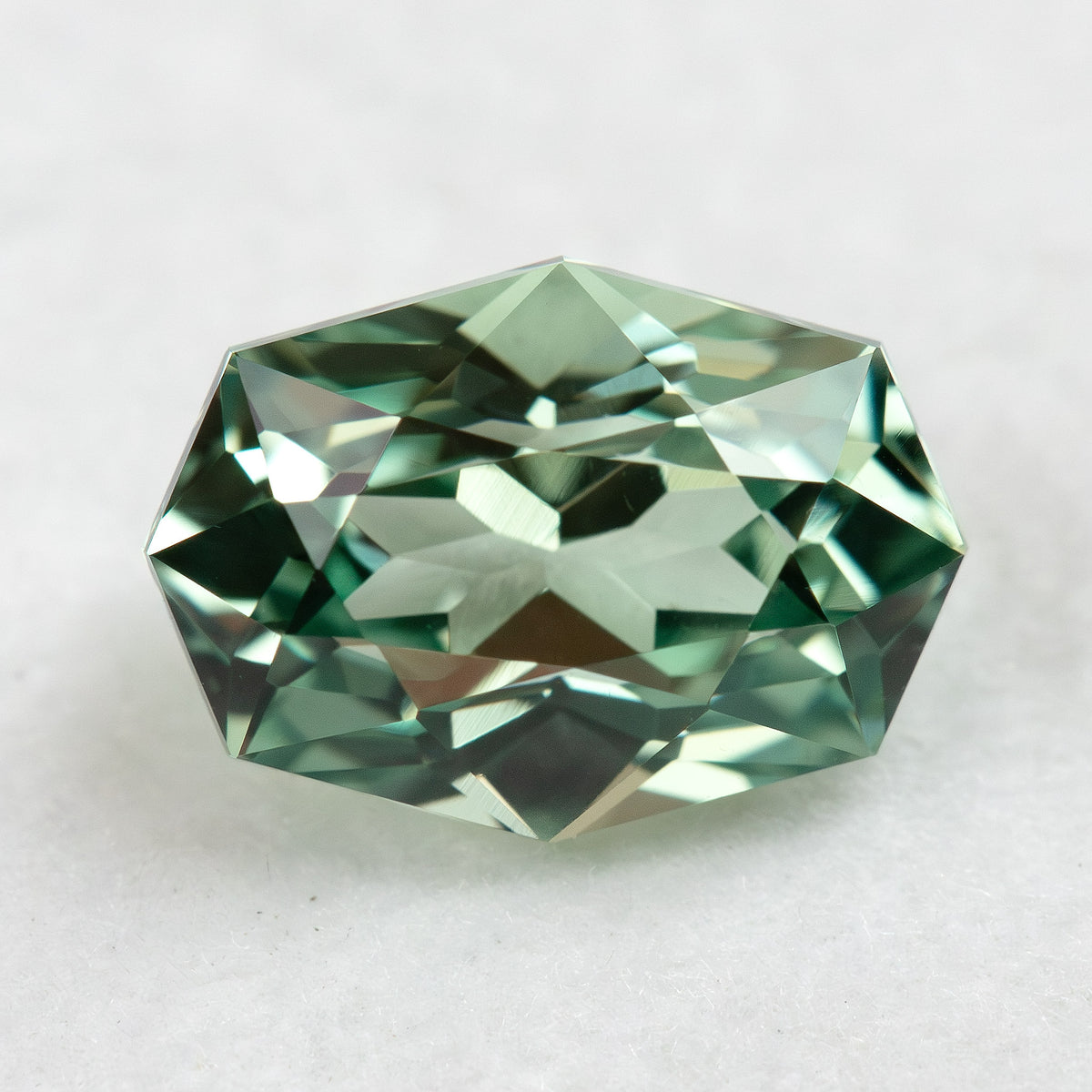 Face-up BLS111 mint green lab-grown sapphire on a white background, showing its geometric fancy cut.