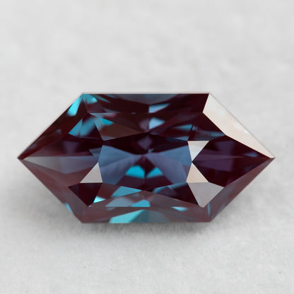 Face-up BLS112 lab-grown alexandrite with red-purple color and greenish-blue reflections.