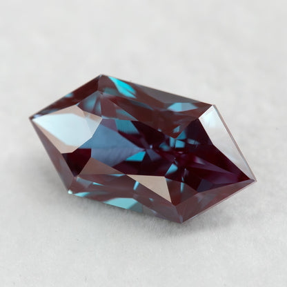 Angled face-up BLS112 alexandrite showing its elongated hexagon outline and facet reflections.