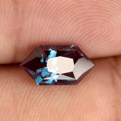 Second fingertip view of the BLS112 lab-grown alexandrite, showing a different reflection pattern and color balance.
