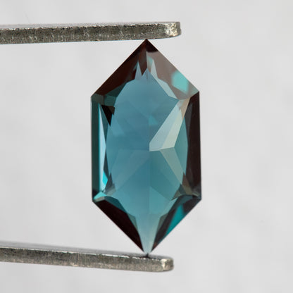 Pavilion and back view of BLS113 lab-grown alexandrite in tweezers, showing the elongated hexagonal outline.