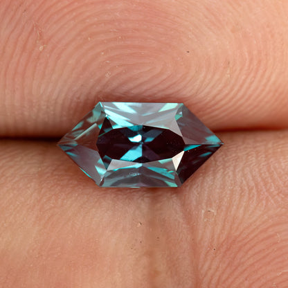 BLS113 color-change lab-grown alexandrite on a fingertip for an approximate sense of its 10 x 5 mm face-up size.