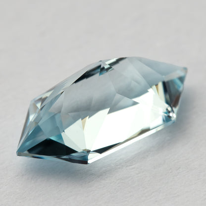 Oblique view of the aquamarine-blue lab-grown sapphire, showing the sloping facets and outline.