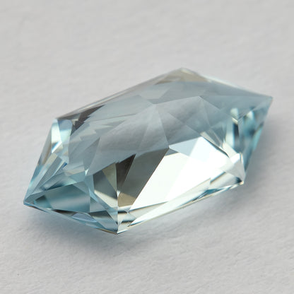 Tilted view of the pale-blue lab-grown sapphire, showing the depth and angular facets.