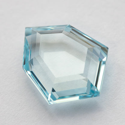 Aquamarine-blue shield-shaped lab-grown sapphire shown at an angle from the pavilion side. View 10.