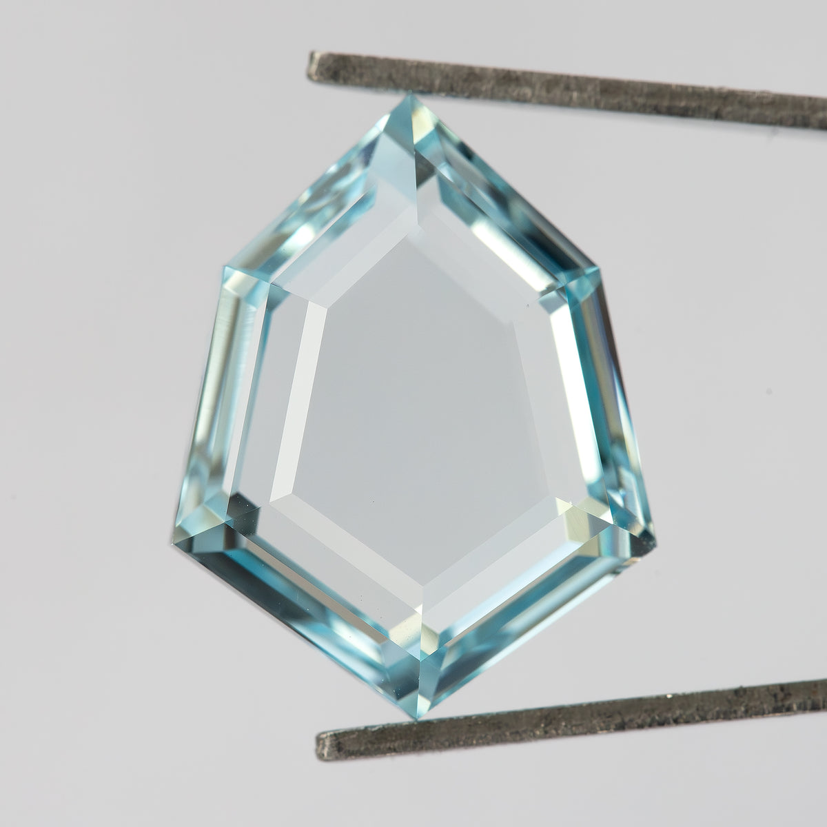 Aquamarine-blue shield-shaped lab-grown sapphire viewed face-up. View 2.
