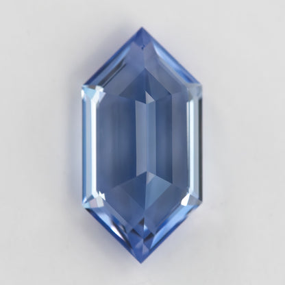 Reverse view of the blue elongated-hexagon sapphire, with broad pale reflections through the underside.