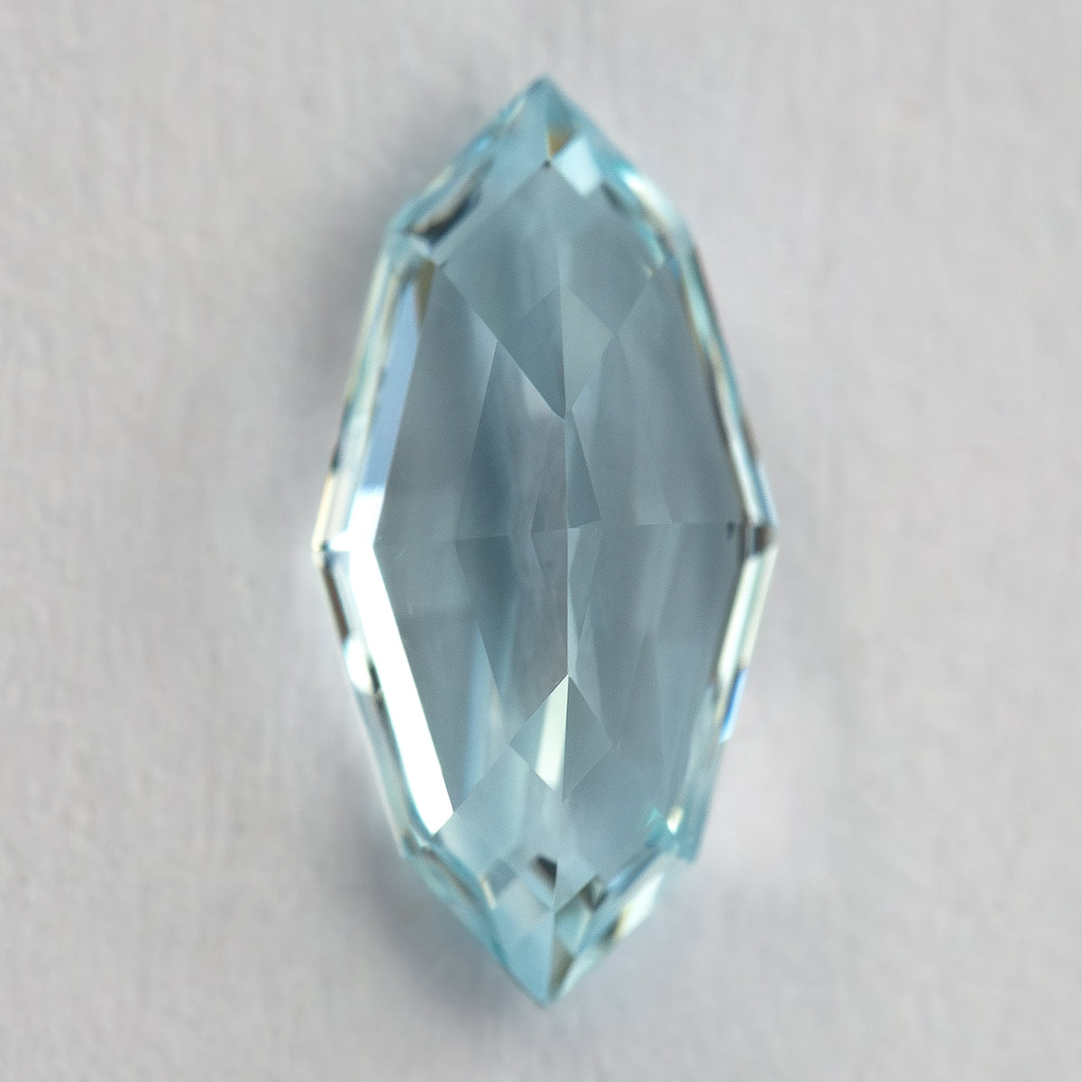 Reverse view of the aquamarine blue / light blue sapphire showing pavilion facets.