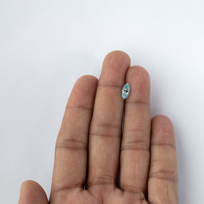 Light blue lab-grown sapphire shown on fingers in a wider hand view for scale.