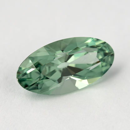 Diagonal crown view of the mint-green lab-grown sapphire, showing its curved sides and pointed ends.