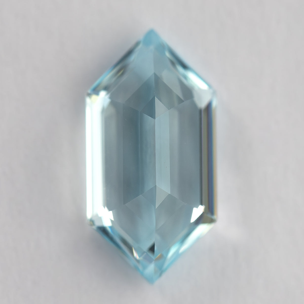 Vertical back-facing view of the aqua-blue lab-grown sapphire, showing broad pavilion reflections.