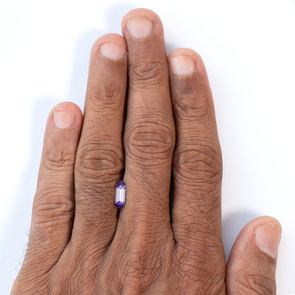 Lavender lab-grown sapphire shown on the back of a hand for scale.