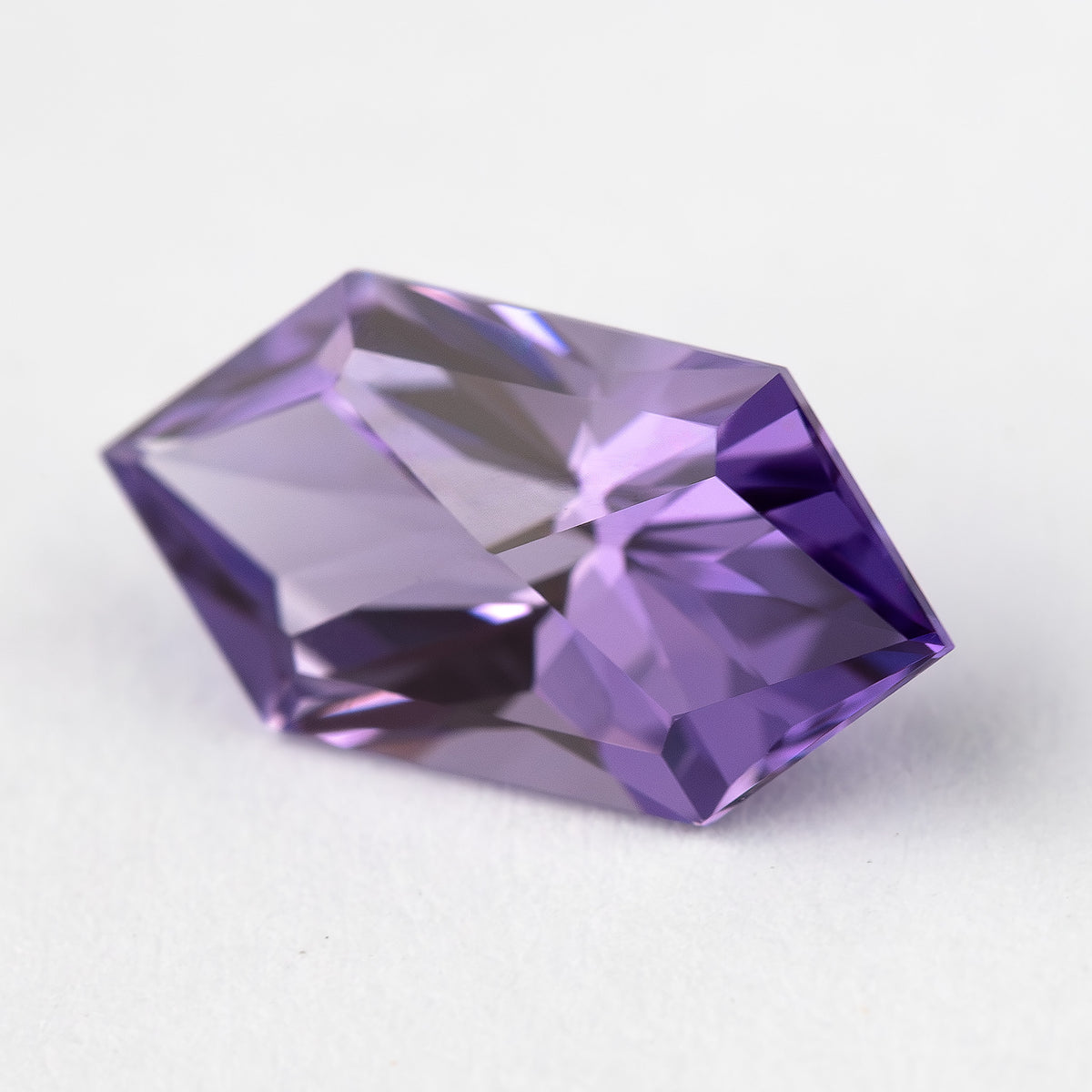 Oblique reverse view of the violet elongated hexagon sapphire, showing broad pavilion facets.