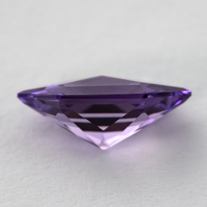 Side view of the violet lab-grown sapphire, showing the pavilion and stone depth.