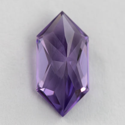 Reverse view of the violet elongated hexagon sapphire, showing its pavilion facets and central ridge.