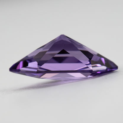 Oblique profile of the violet lab-grown sapphire showing depth and pavilion faceting.