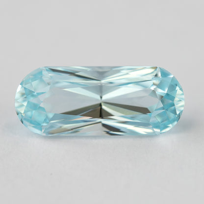 Elongated light blue sapphire with bright reflections along the center facets.