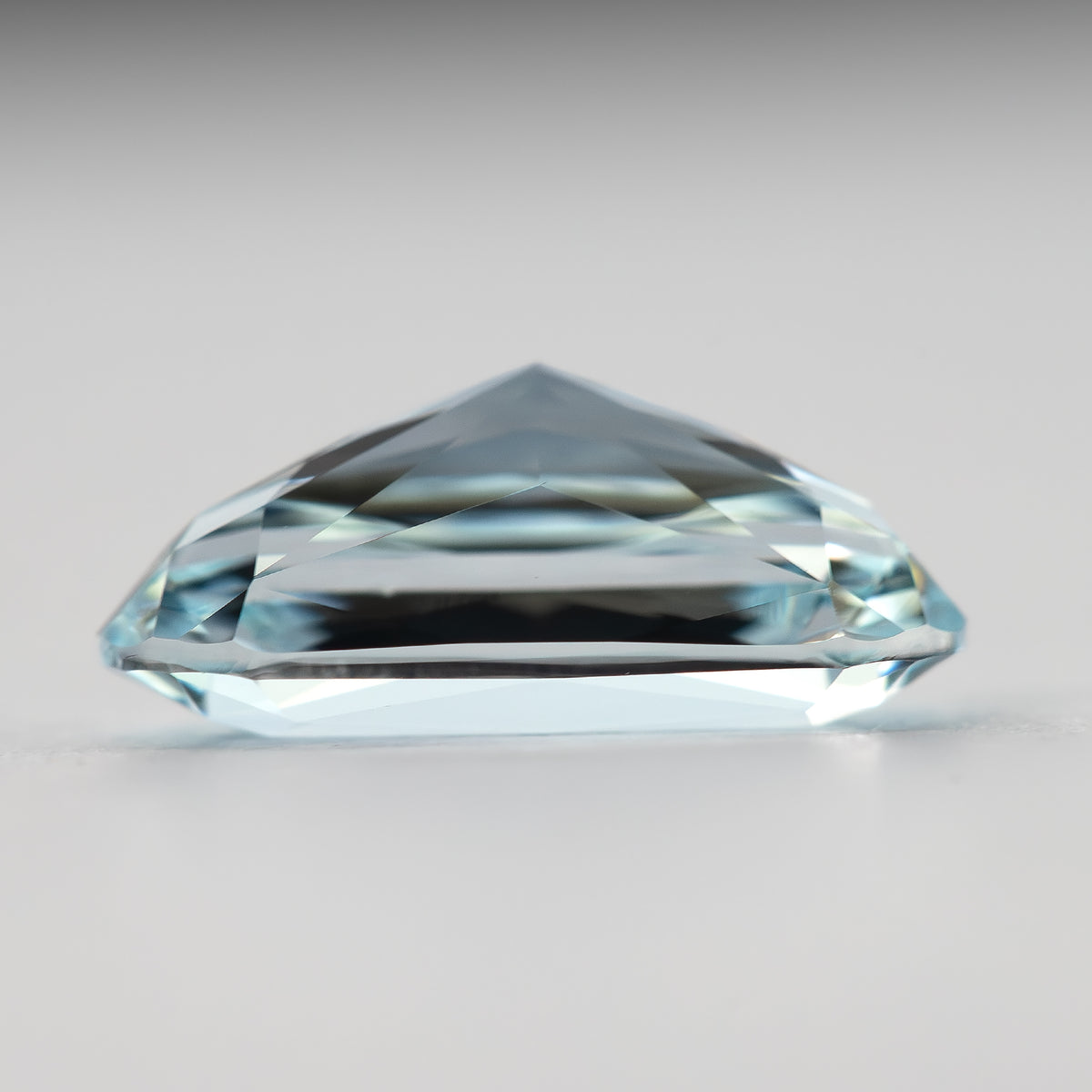 Lower side view of the elongated sapphire, showing its domed profile.